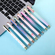 Tám cây bút màu sắc khác nhau nằm trên bàn phím laptop nền xanh nhạt.