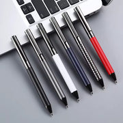 Sáu cây bút bi nhiều màu sắc, đặt cạnh bàn phím laptop màu bạc trên nền xám.