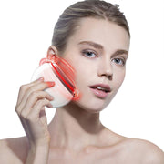 Người phụ nữ dùng thiết bị trắng phát sáng đỏ áp lên má, nền trắng.