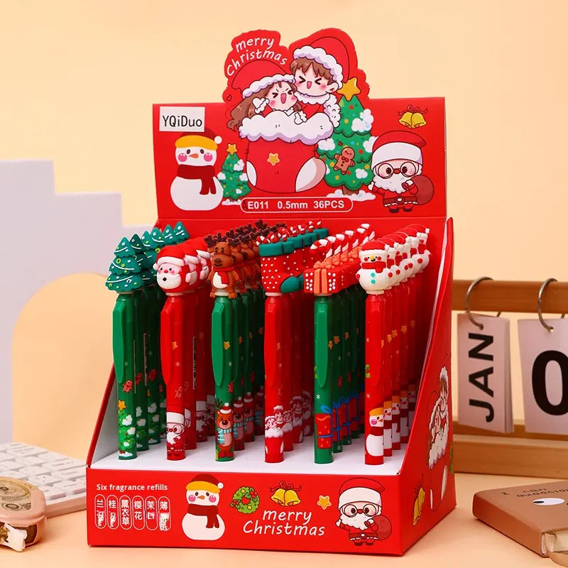 Bộ bút Giáng Sinh trên giá đỡ đỏ, có hình ông Noel và cây thông, màu xanh lá và đỏ nổi bật.