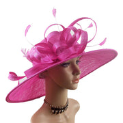 Mannequin đội mũ rộng vành màu hồng, trang trí nơ và lông vũ, đeo vòng cổ đen.