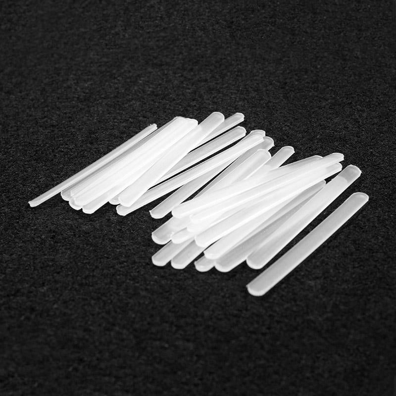Nhiều que nhựa trắng xếp chồng trên nền màu đen.