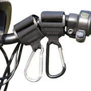 Tay lái xe đạp với dây đen và hai móc carabiner màu đen và bạc gắn vào.