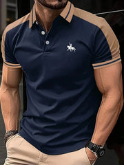Áo polo xanh navy viền nâu, logo kỵ sĩ trắng, tay ngắn, quần kaki sáng màu.