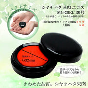 Hộp mực đỏ nhỏ gọn, nắp đen, kích thước 32mm, nền xanh lá nhạt với họa tiết lá cây.
