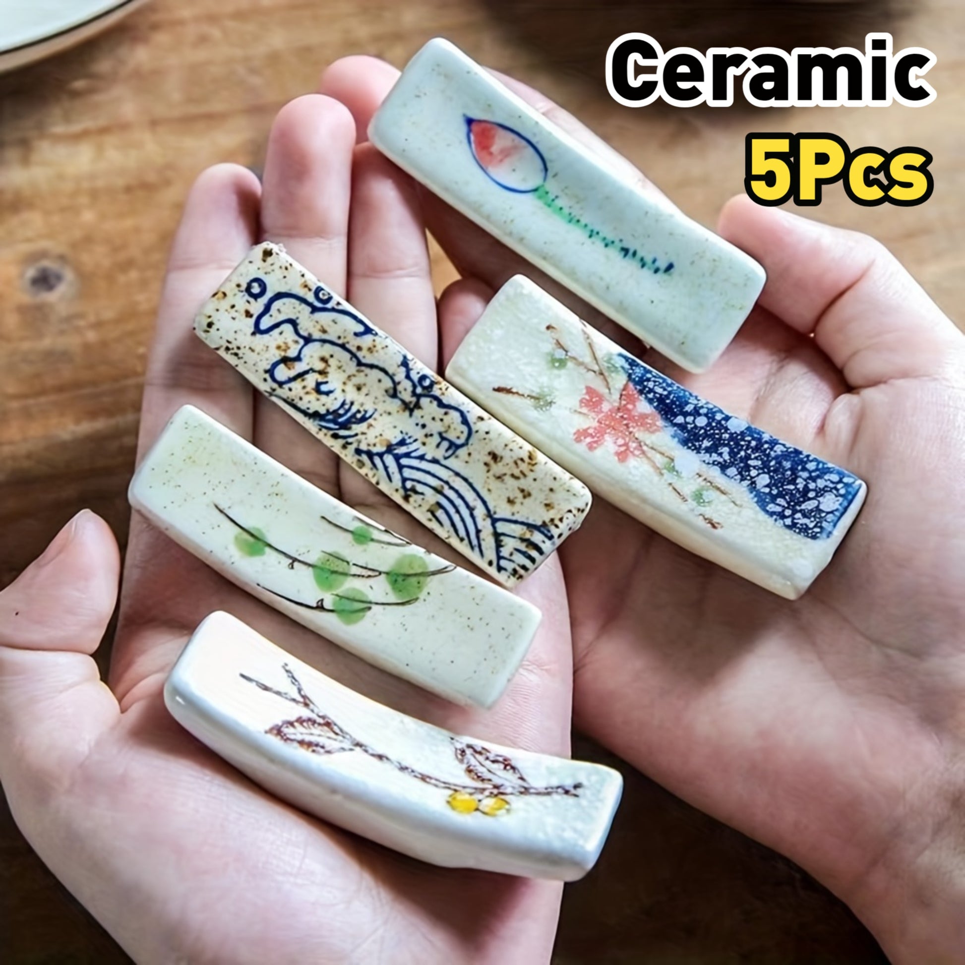 5 gác đũa sứ trong tay, màu sắc và hoa văn đa dạng, nền gỗ.
