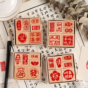 Bốn hộp gỗ vuông chứa các con dấu chữ Hán đỏ, xung quanh có giấy viết và cọ vẽ.
