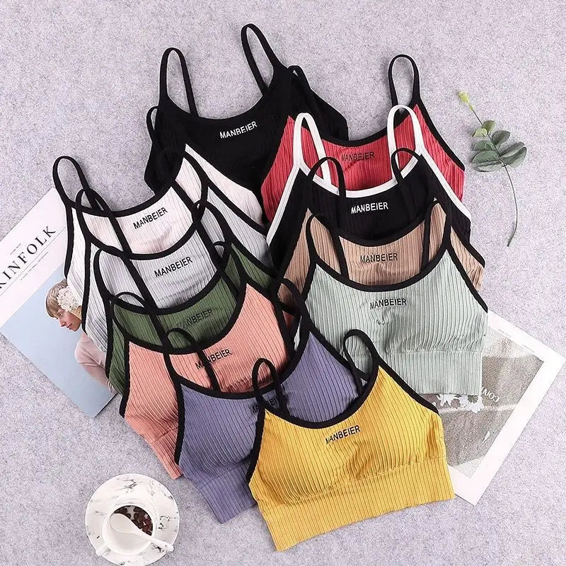 Áo lót nhiều màu sắc xếp chồng, gồm đen, trắng, đỏ, xanh, vàng, trên nền xám.