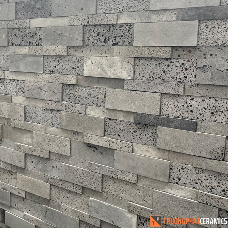 Tường gạch xếp chồng màu xám, họa tiết lỗ nhỏ, bề mặt thô và tự nhiên.