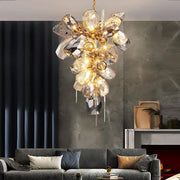 Đèn chùm pha lê lấp lánh, ánh sáng vàng, treo trên trần, phòng khách với sofa xám và rèm xanh.