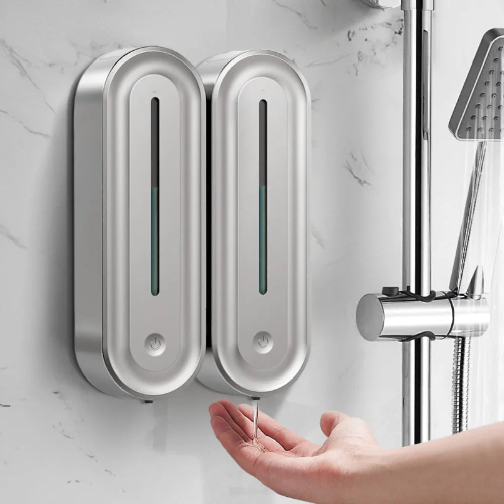 Hai bình đựng xà phòng inox treo tường, tay người hứng xà phòng chảy ra.