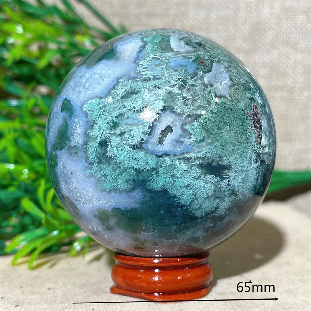 Quả cầu đá xanh lục mờ, vân trắng và xanh đậm, đặt trên đế gỗ màu nâu, kích thước 65mm.