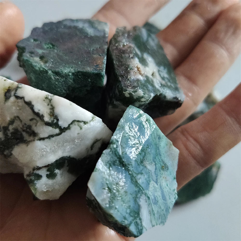 Các khối đá xanh rêu và trắng, hoa văn tự nhiên, nằm trên lòng bàn tay người.