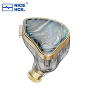 Tai nghe in-ear vỏ nhựa trong suốt, mặt ốp xoáy xanh và vàng kim. Logo NICEHCK góc trái trên.