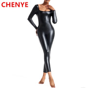 Người mẫu mặc bộ bodysuit đen bóng dài tay, đứng trên nền trắng.