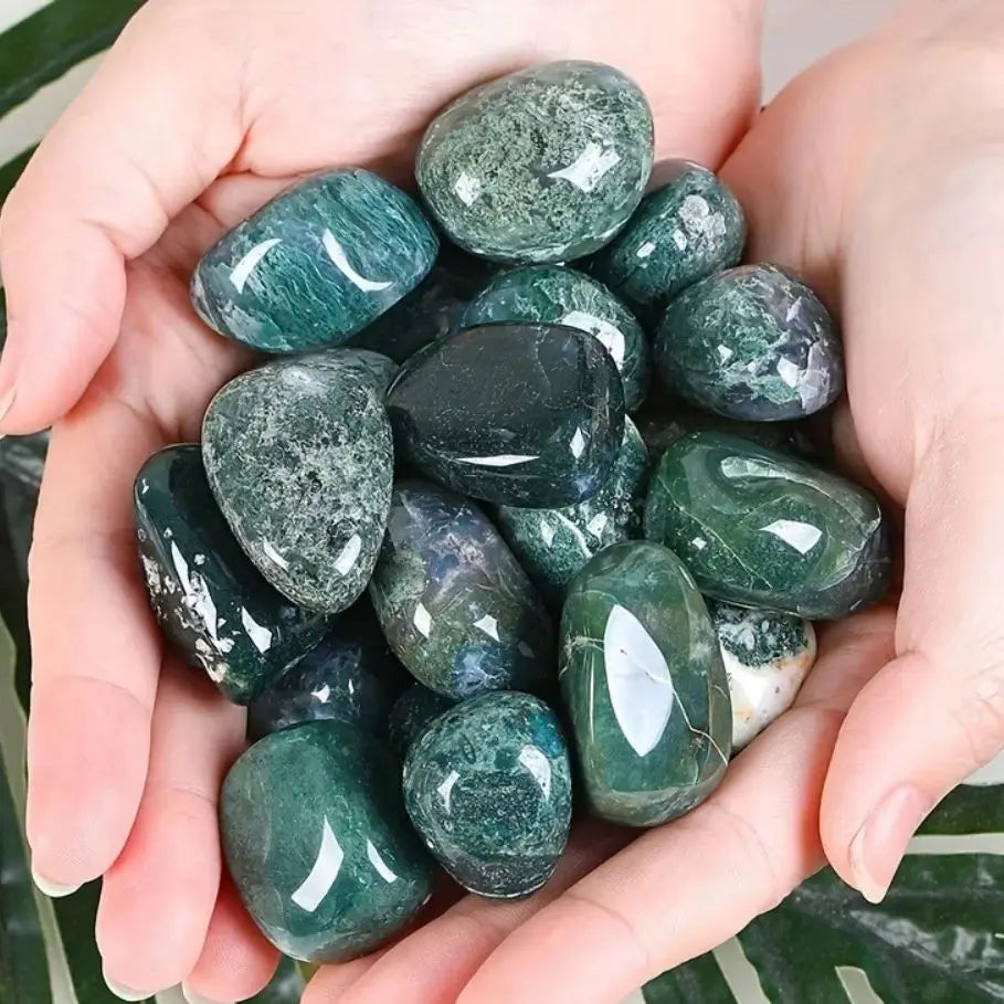 Hai bàn tay nâng những viên đá xanh, bề mặt bóng loáng và màu sắc đa dạng.