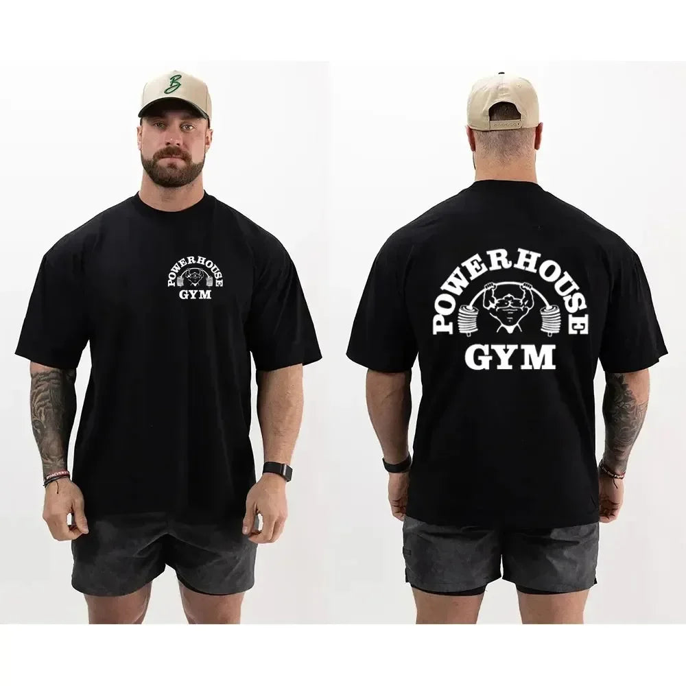 Người mặc áo đen có logo "Powerhouse Gym" trắng, quần ngắn xám, đội mũ lưỡi trai be.