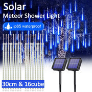 Đèn LED mưa sao băng xanh, bảng năng lượng mặt trời, nền cây cối, chữ "ip65 waterproof".