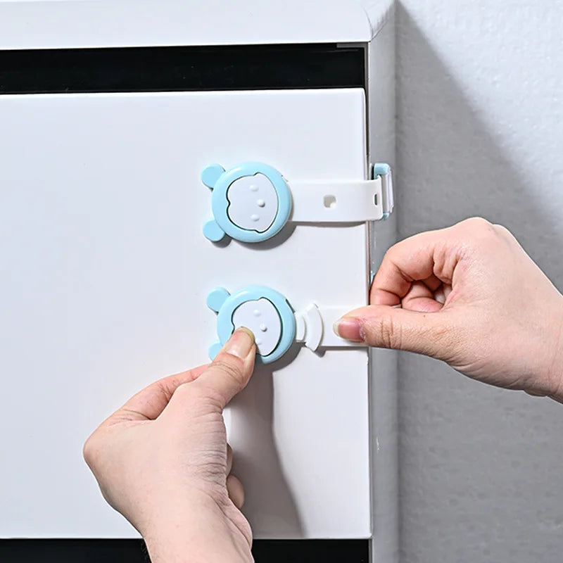 Tay đang mở khóa an toàn màu xanh dương trên tủ trắng.