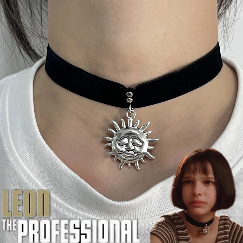 Dây chuyền choker đen với mặt dây mặt trời bạc trên cổ người, kèm ảnh nhân vật nữ phía dưới.