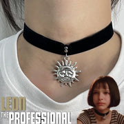 Dây chuyền choker đen với mặt dây mặt trời bạc trên cổ người, kèm ảnh nhân vật nữ phía dưới.