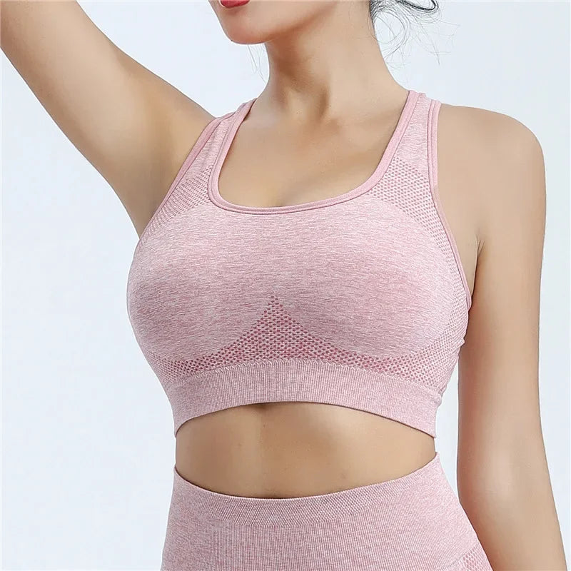 Người mặc áo thể thao hồng nhạt, chất liệu co giãn, cắt ôm sát cơ thể.