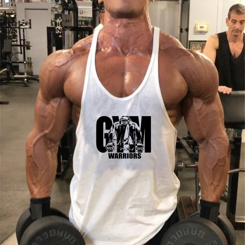Người đàn ông cơ bắp mặc áo ba lỗ trắng, cầm tạ đen trong phòng tập gym.