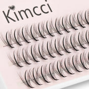 Hộp mi giả màu đen xếp thành hàng trên nền hồng nhạt với chữ "Kimcci" ở góc trên.
