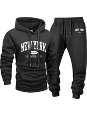 Bộ đồ thể thao màu đen, áo hoodie và quần dài, chữ trắng "New York" nổi bật.
