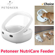 Máy cho ăn tự động Petoneer NutriCare màu trắng, mèo đang ăn từ máy trên sàn gỗ.