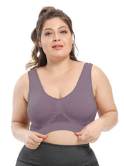 Người phụ nữ mặc áo bralette màu tím nhạt, tóc buộc cao, nền trắng.