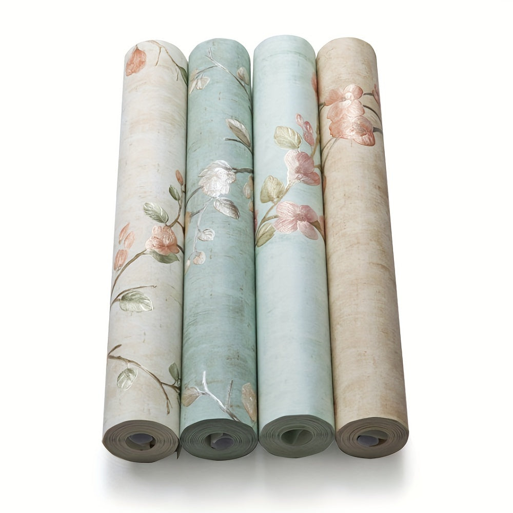 Bốn cuộn giấy dán tường màu pastel, họa tiết hoa lá nhẹ nhàng.