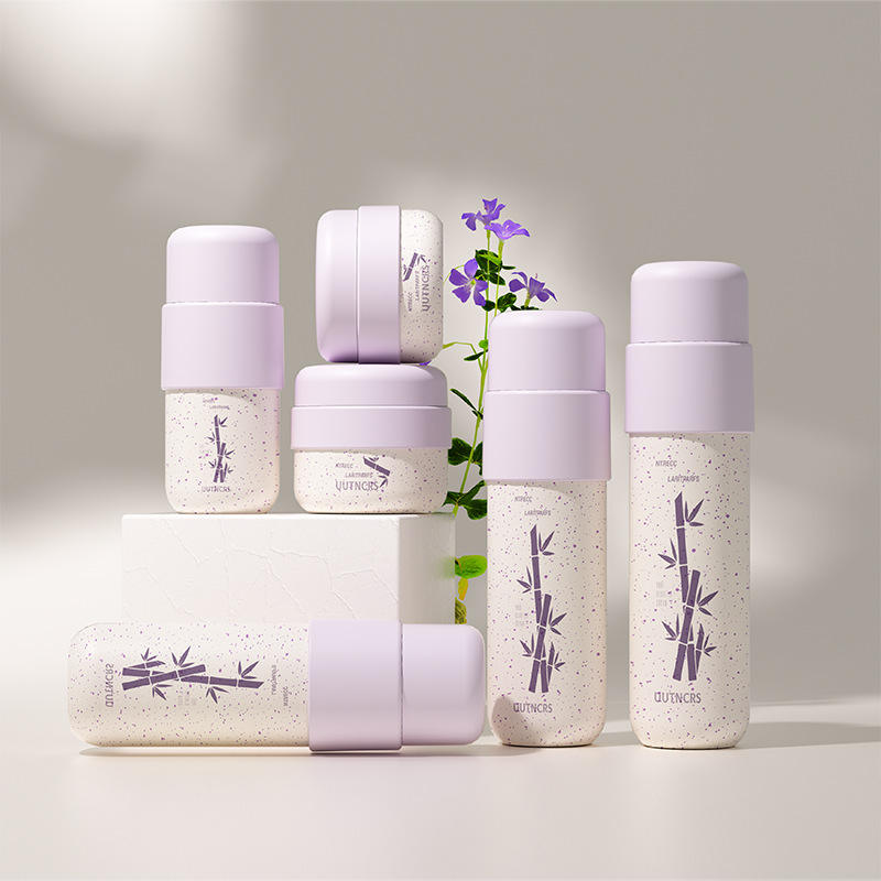 Các chai kem màu tím nhạt, họa tiết tre tím, đặt trên nền trắng, kèm hoa tím.