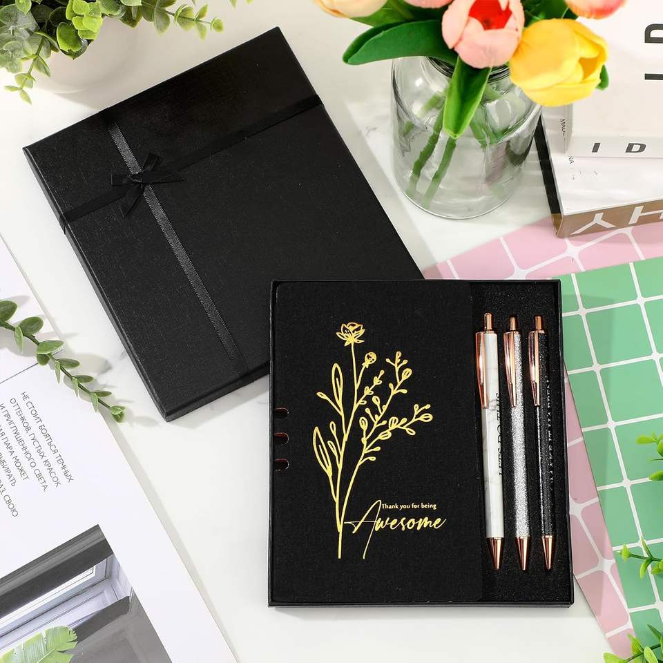 Hộp quà đen có hoa vàng và chữ "Awesome", kèm ba bút bên cạnh lọ hoa tulip.