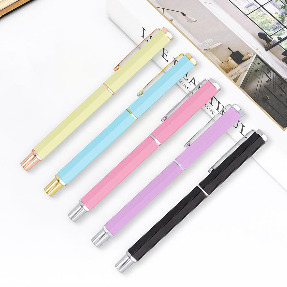 Năm bút bi màu vàng, xanh, hồng, tím và đen với kẹp kim loại trên nền trắng.