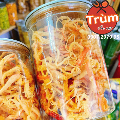 Hai hũ nhựa chứa mực khô xé sợi màu vàng cam, nhãn hiệu Trùm Ăn Vặt nổi bật.