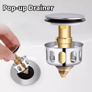 Bộ xả nước pop-up màu bạc và vàng, một tay đang thao tác lắp vào lỗ thoát nước.