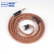 Dây tai nghe xoắn đồng màu nâu, đầu cắm 3.5mm mạ vàng, nền trắng.