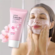 Người phụ nữ rửa mặt với sữa rửa mặt màu hồng, hình hoa anh đào, chất kem trắng.