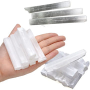 Tay cầm các thanh đá trắng, bóng, dài xếp chồng cạnh nhau trên nền trắng.