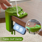 Thiết bị chơi golf mini màu xanh gắn trên bàn, với tay và nút điều chỉnh.
