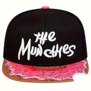 Nón lưỡi trai đen, chữ trắng "The Munchies", vành nón họa tiết bánh donut hồng.