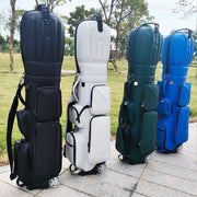 Bốn túi golf màu đen, trắng, xanh lá, xanh dương đứng trên vỉa hè, phía sau là cỏ xanh và cây cối.