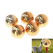 Năm quả bóng golf màu vàng ánh kim, một quả trên cỏ với gậy golf.