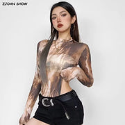 Người phụ nữ mặc áo dài tay họa tiết nâu, quần đen, đeo hoa tai vòng tròn và dây chuyền.