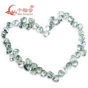Hạt đá hình trái tim màu xanh lục xếp thành hình trái tim trên nền trắng.