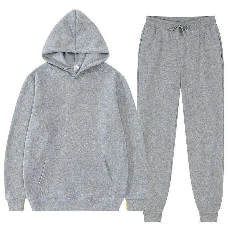 Bộ đồ nỉ xám gồm áo hoodie có mũ và quần dài, chất liệu vải mềm mại.