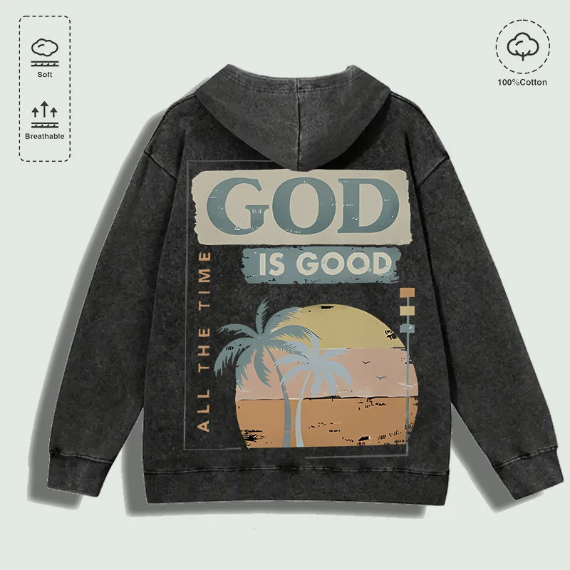 Áo hoodie đen với dòng chữ "God is Good", hình ảnh cây cọ và mặt trời hoàng hôn phía sau.