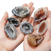 Bàn tay cầm bảy viên đá thạch anh màu xám và nâu, bề mặt lấp lánh và kết cấu độc đáo.