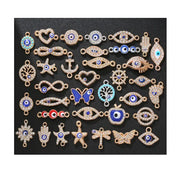 Nhiều charm trang sức hình mắt, bướm, ngôi sao, chủ yếu màu xanh dương và vàng trên nền đen.
